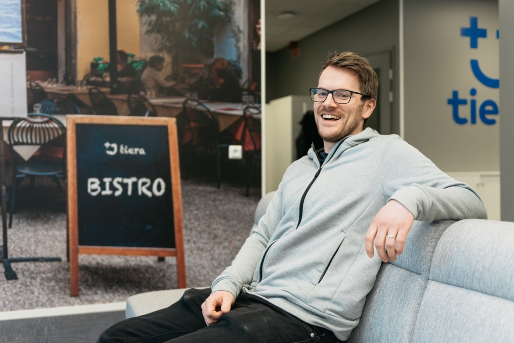 Toimistovastaava Ville Toppila Kuntien Tieralta hymyilee istuessaan rennosti sohvalla.